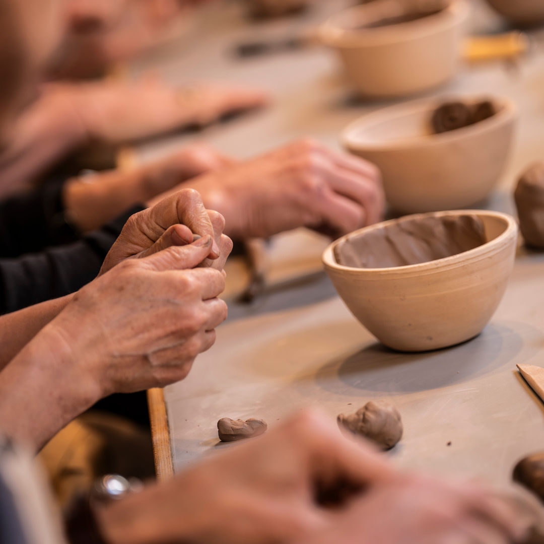 Photo depicting hands working with clay