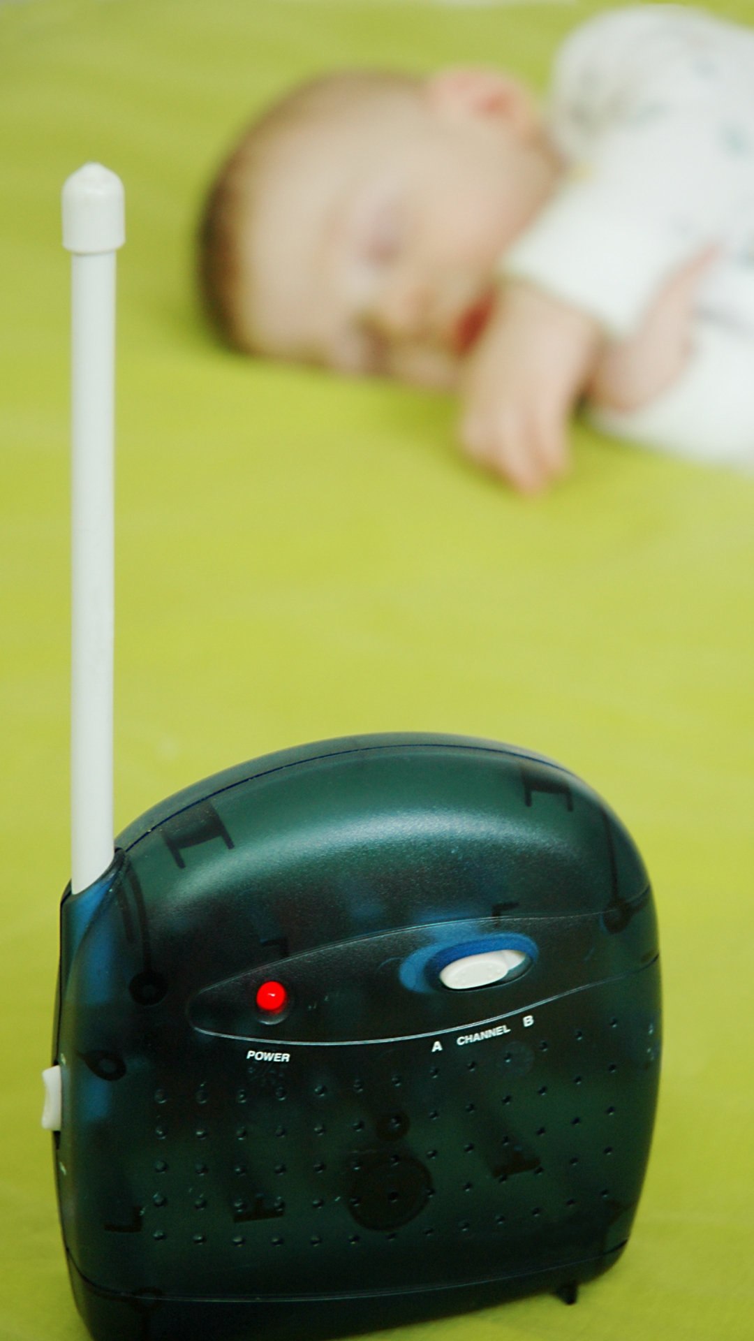 Baby monitor with baby sleeping in the background