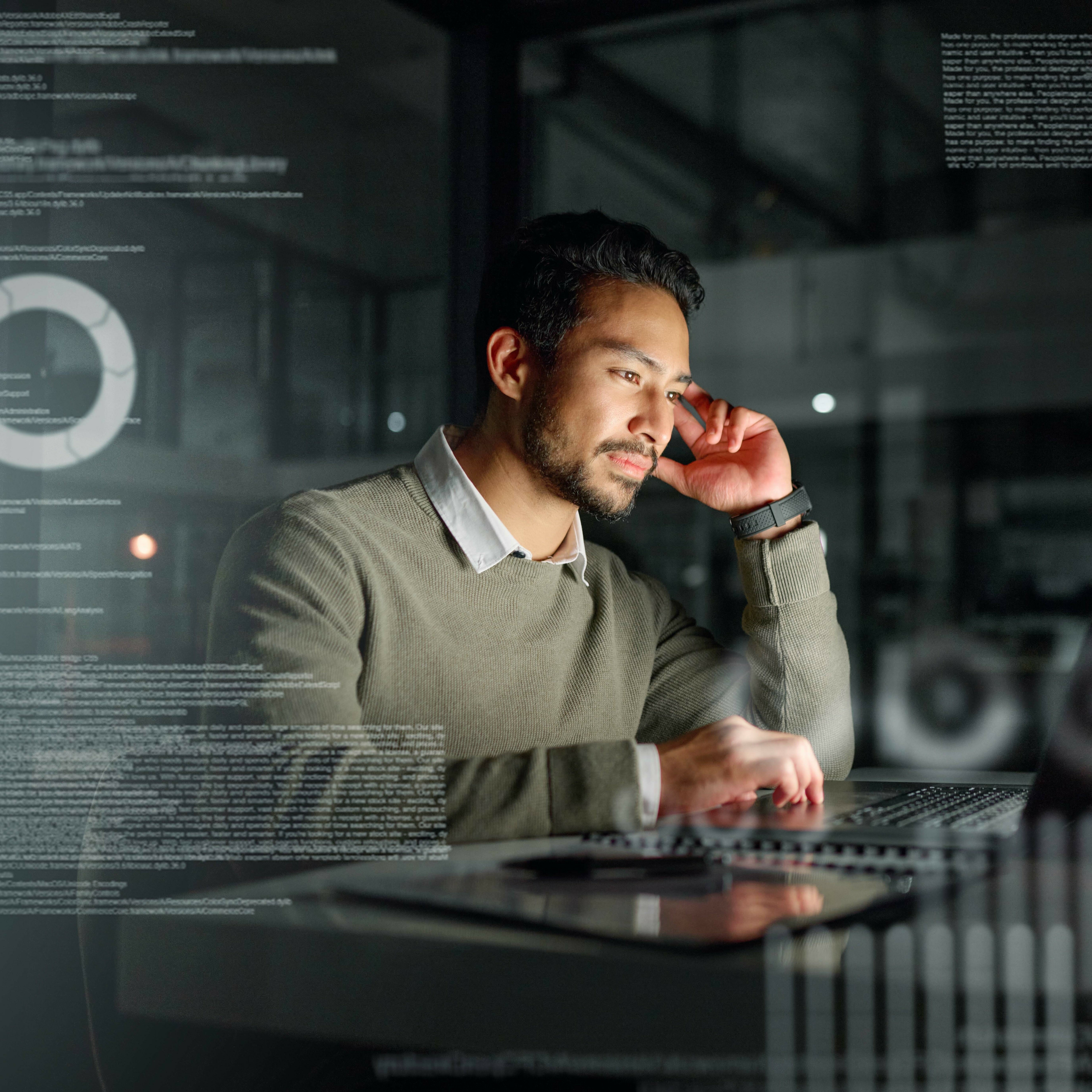 a man in deep thought sat in a dark room working on a laptop - decoration only