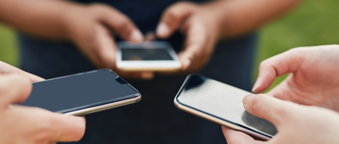 Three pairs of hands holding smart phones
