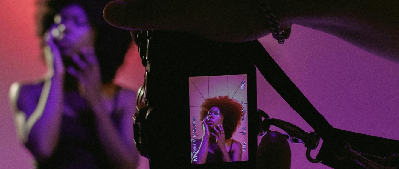 People filming, with a preview visible through a camera