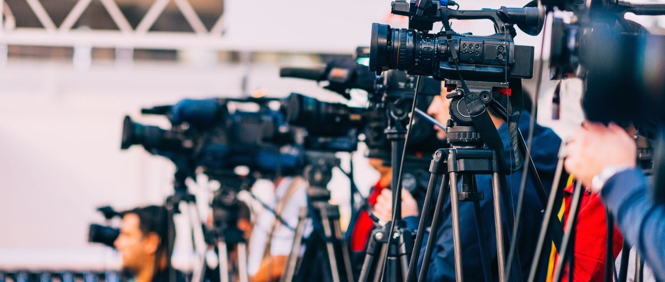 Cameras in a row filming a news event