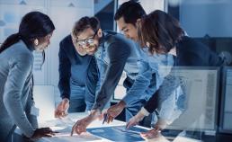 Stock image of workers around a table
